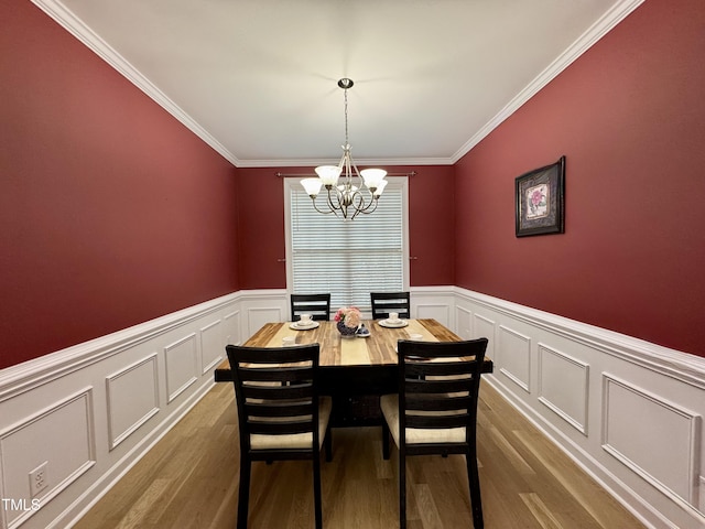 71 Beaver Creek Dr, Dunn, NC 28334 - dining space featuring a chandelier, a decorative wall, wainscoting, dark wood-style floors, and ornamental molding
