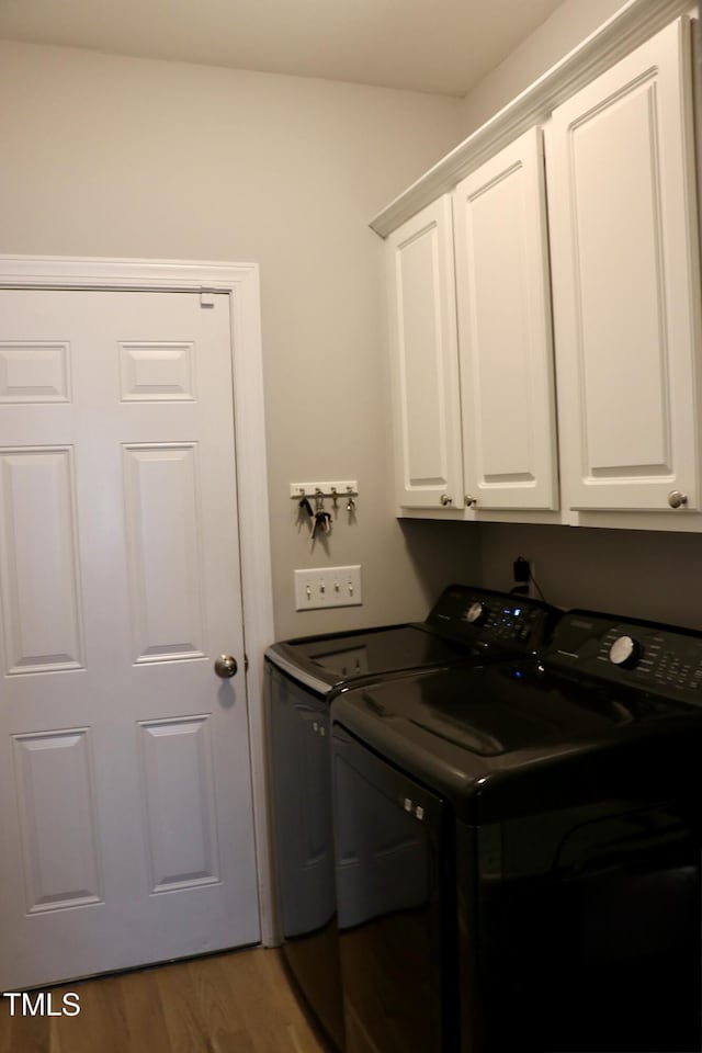 71 Beaver Creek Dr, Dunn, NC 28334 - laundry area featuring washer and dryer, cabinet space, and wood finished floors