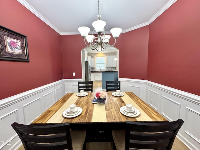 71 Beaver Creek Dr, Dunn, NC 28334 - dining area featuring a chandelier, a decorative wall, wainscoting, and crown molding