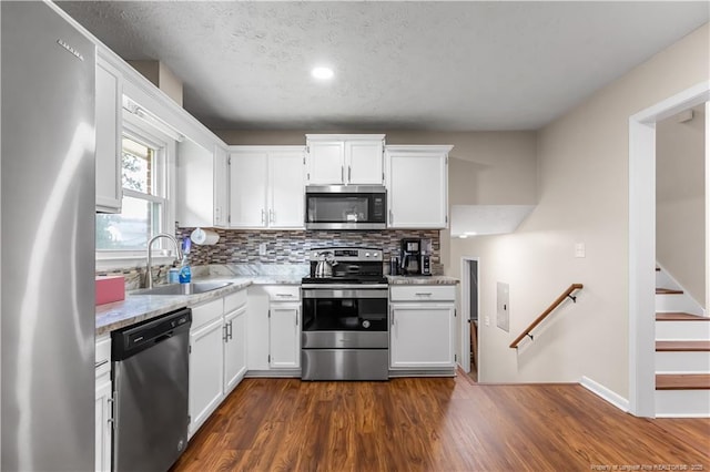 1524 Stackhouse Dr, Fayetteville, NC 28314 - kitchen with stainless steel appliances, white cabinets, tasteful backsplash, dark wood finished floors, and recessed lighting