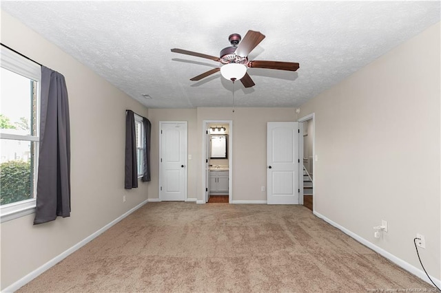 1524 Stackhouse Dr, Fayetteville, NC 28314 - unfurnished bedroom featuring light carpet, a textured ceiling, ensuite bathroom, and ceiling fan