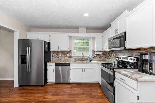 1524 Stackhouse Dr, Fayetteville, NC 28314 - kitchen featuring stainless steel appliances, decorative backsplash, a textured ceiling, white cabinetry, and recessed lighting