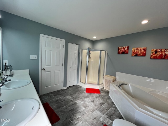 8836 Thornton Garden Ln, Raleigh, NC 27616 - bathroom featuring a bath, a shower stall, double vanity, wood finished floors, and recessed lighting