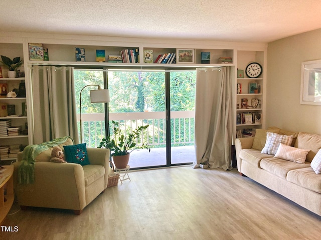 500 Umstead Dr Unit D307, Chapel Hill, NC 27516 - living area with wood finished floors, a textured ceiling, and healthy amount of natural light