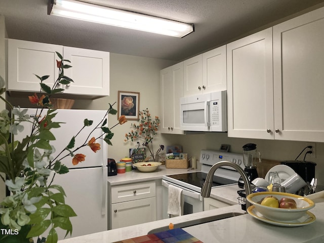 500 Umstead Dr Unit D307, Chapel Hill, NC 27516 - kitchen featuring white appliances, light countertops, white cabinetry, and a textured ceiling