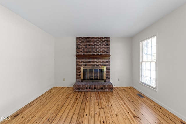 3309 Bearskin Ct, Raleigh, NC 27606 - unfurnished living room featuring hardwood / wood-style flooring and a brick fireplace