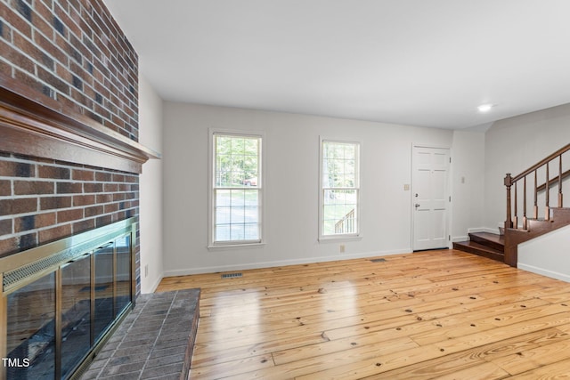 3309 Bearskin Ct, Raleigh, NC 27606 - unfurnished living room with a fireplace, wood-type flooring, stairway, and recessed lighting