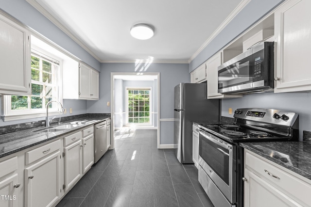 3309 Bearskin Ct, Raleigh, NC 27606 - kitchen with appliances with stainless steel finishes, white cabinets, crown molding, and dark stone counters