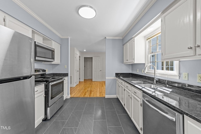 3309 Bearskin Ct, Raleigh, NC 27606 - kitchen with stainless steel appliances, ornamental molding, white cabinets, dark stone counters, and dark tile patterned flooring