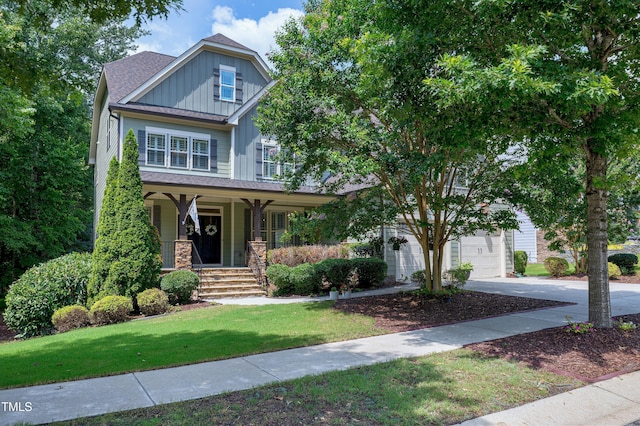 1013 Shasta Daisy Dr, Wake Forest, NC 27587 - view of front of home featuring board and batten siding, a porch, a front yard, concrete driveway, and a garage