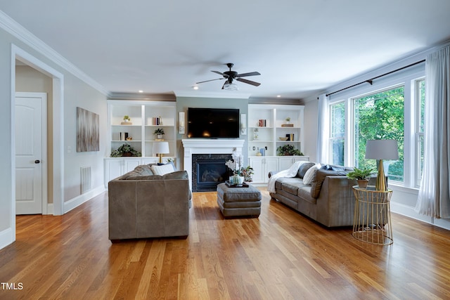 1013 Shasta Daisy Dr, Wake Forest, NC 27587 - living room featuring ceiling fan, a glass covered fireplace, wood finished floors, ornamental molding, and built in features
