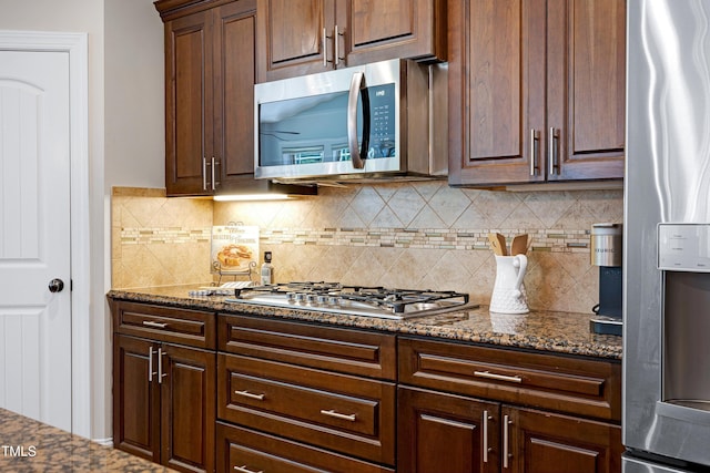 1013 Shasta Daisy Dr, Wake Forest, NC 27587 - kitchen with appliances with stainless steel finishes, tasteful backsplash, dark stone countertops, and dark brown cabinetry