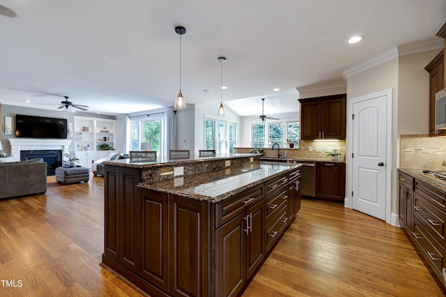 1013 Shasta Daisy Dr, Wake Forest, NC 27587 - kitchen with ceiling fan, a fireplace, open floor plan, light wood finished floors, and recessed lighting