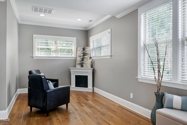 1013 Shasta Daisy Dr, Wake Forest, NC 27587 - sitting room featuring plenty of natural light, wood finished floors, crown molding, a fireplace with raised hearth, and recessed lighting