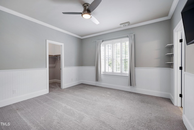 1013 Shasta Daisy Dr, Wake Forest, NC 27587 - empty room featuring a wainscoted wall, ceiling fan, carpet, and crown molding