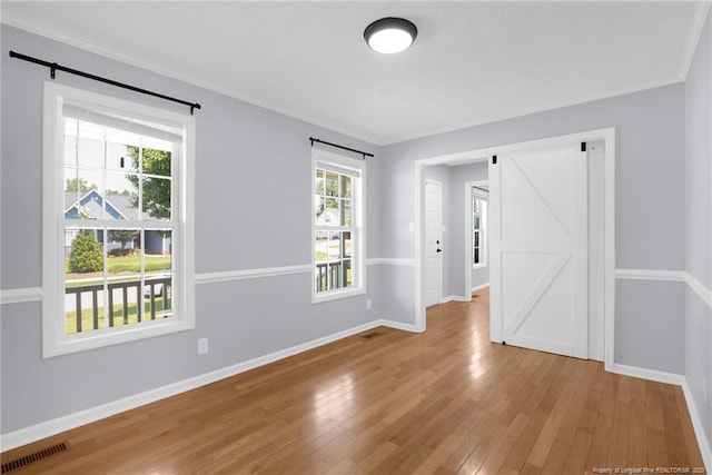 2505 Canford Ln, Fayetteville, NC 28304 - spare room with a barn door, wood-type flooring, and ornamental molding