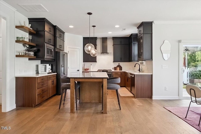 1848 Stagecoach Trl, Wendell, NC 27591 - kitchen with premium appliances, light wood-style flooring, a center island, wall chimney exhaust hood, and ornamental molding