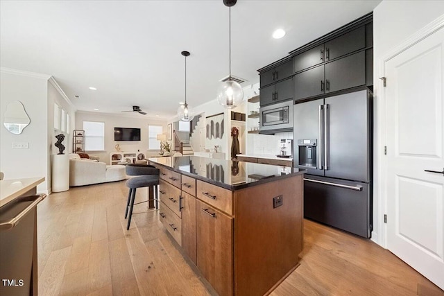 1848 Stagecoach Trl, Wendell, NC 27591 - kitchen featuring stainless steel appliances, a kitchen island, crown molding, light wood finished floors, and dark cabinets