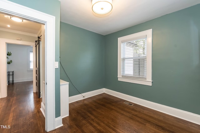 415 W Carver St, Durham, NC 27704 - unfurnished room featuring dark wood-style flooring, a barn door, and ornamental molding