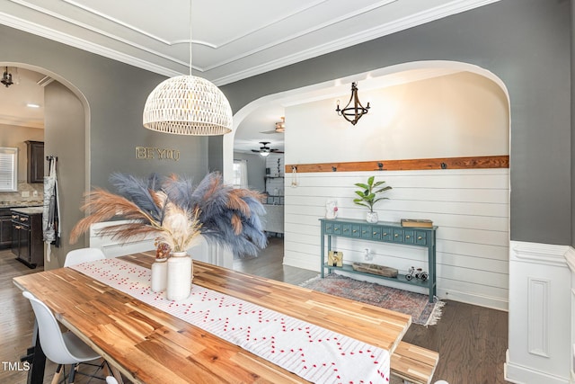 2407 Cattail Pond Dr, Zebulon, NC 27597 - dining space with arched walkways, dark wood-style floors, ornamental molding, a ceiling fan, and a chandelier