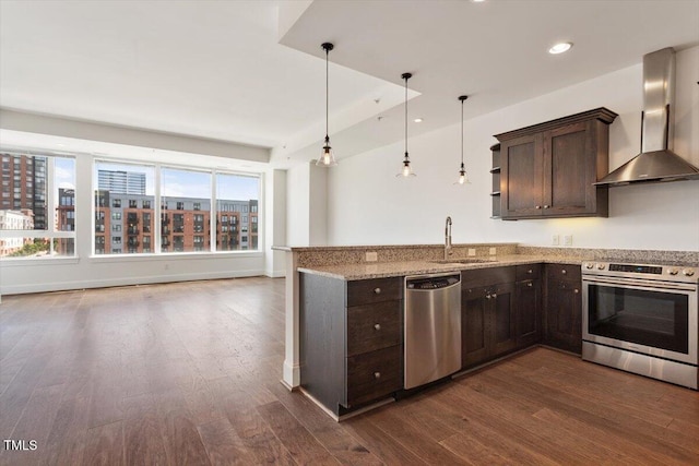 400 W N St Unit 732, Raleigh, NC 27603 - kitchen with appliances with stainless steel finishes, wall chimney range hood, dark brown cabinetry, dark wood-style floors, and a peninsula
