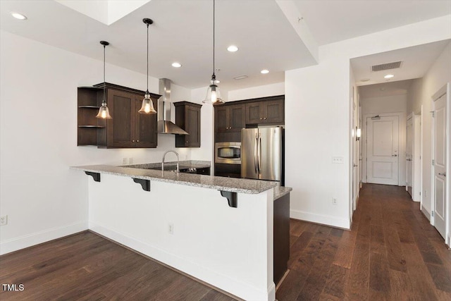 400 W N St Unit 732, Raleigh, NC 27603 - kitchen featuring appliances with stainless steel finishes, wall chimney exhaust hood, a peninsula, dark brown cabinets, and a breakfast bar