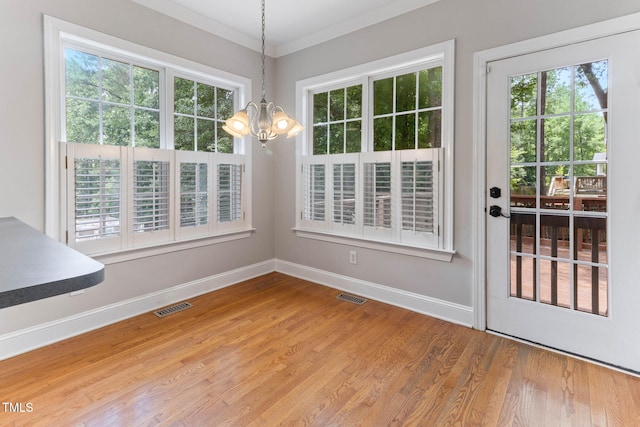 8508 Parlange Woods Ln, Wake Forest, NC 27587 - unfurnished dining area featuring a chandelier, healthy amount of natural light, wood finished floors, and crown molding