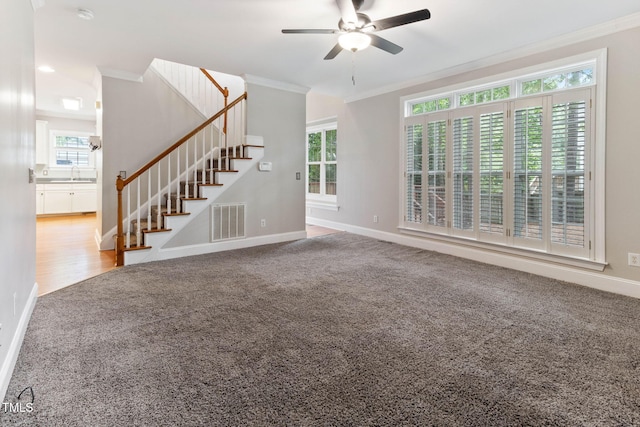 8508 Parlange Woods Ln, Wake Forest, NC 27587 - unfurnished living room with crown molding, carpet, ceiling fan, stairs, and plenty of natural light