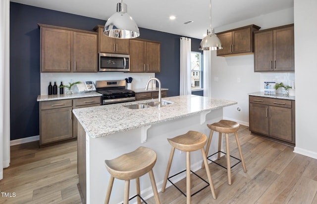 1516 Tamarisk Ln, Durham, NC 27703 - kitchen featuring appliances with stainless steel finishes, tasteful backsplash, light wood-style flooring, decorative light fixtures, and recessed lighting