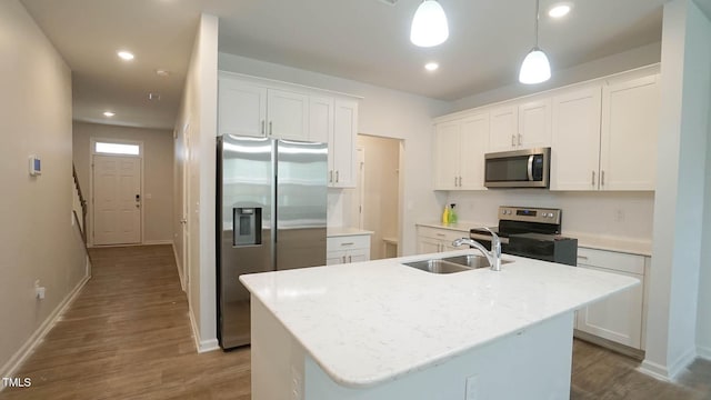 103 Liam St Unit 108, Clayton, NC 27520 - kitchen featuring appliances with stainless steel finishes, dark wood-type flooring, white cabinetry, a kitchen island with sink, and pendant lighting