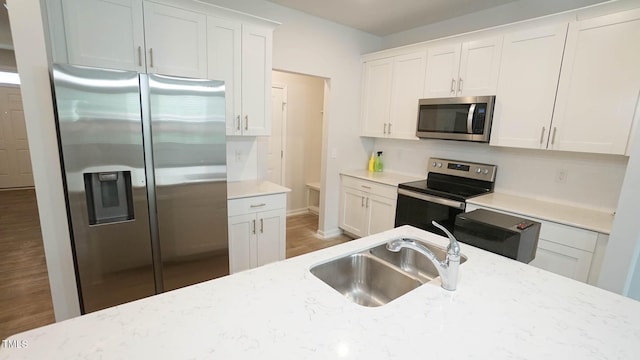 103 Liam St Unit 108, Clayton, NC 27520 - kitchen with stainless steel appliances, white cabinetry, and light stone counters