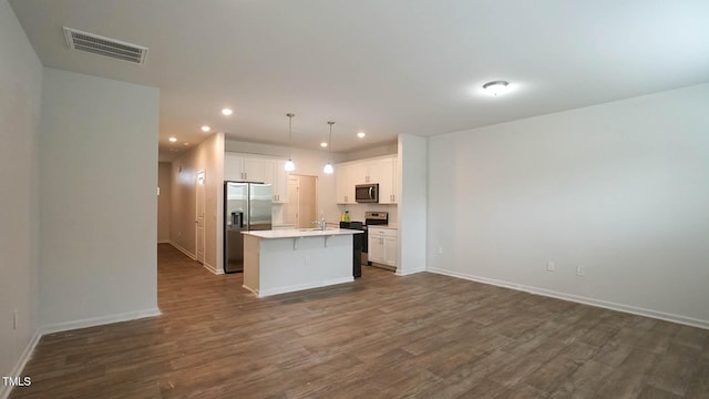 103 Liam St Unit 108, Clayton, NC 27520 - kitchen featuring appliances with stainless steel finishes, recessed lighting, open floor plan, dark wood finished floors, and an island with sink