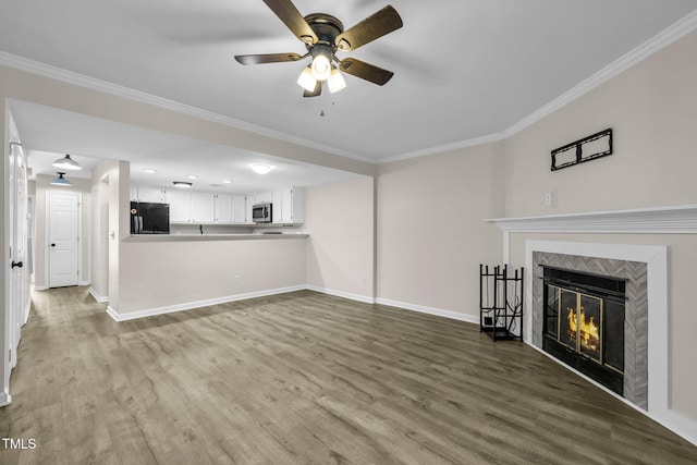 2233 Alpine Rd, Durham, NC 27707 - unfurnished living room featuring a ceiling fan, wood finished floors, a tiled fireplace, and crown molding