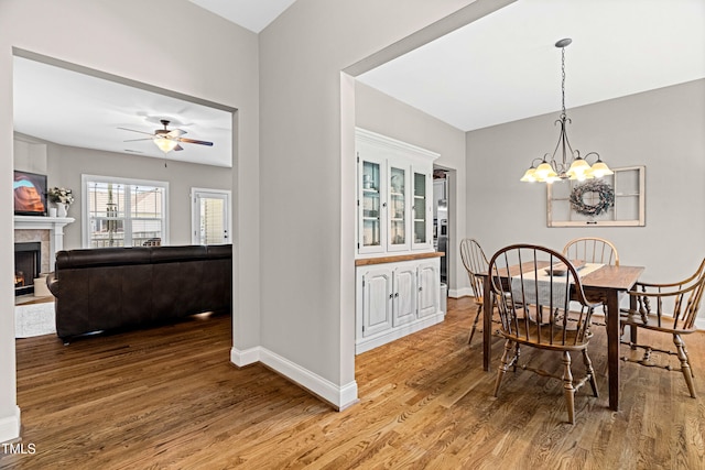 20 Kola Nut, Smithfield, NC 27577 - dining area with light wood-style flooring, ceiling fan, a warm lit fireplace, and a chandelier