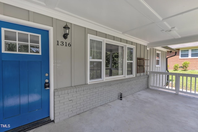 1316 Foxrun Dr, Raleigh, NC 27610 - view of exterior entry featuring a porch, board and batten siding, and brick siding