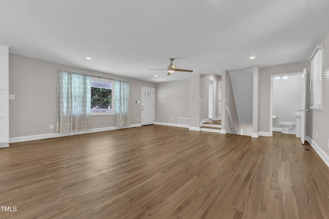 1316 Foxrun Dr, Raleigh, NC 27610 - unfurnished living room with a ceiling fan, wood finished floors, recessed lighting, and stairs