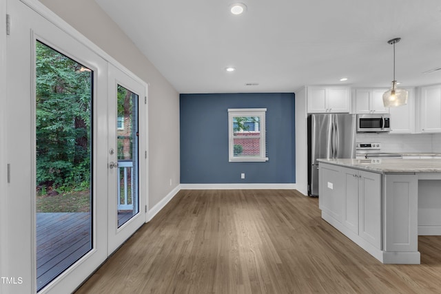 1316 Foxrun Dr, Raleigh, NC 27610 - kitchen with stainless steel appliances, light wood-style flooring, white cabinets, light stone countertops, and tasteful backsplash
