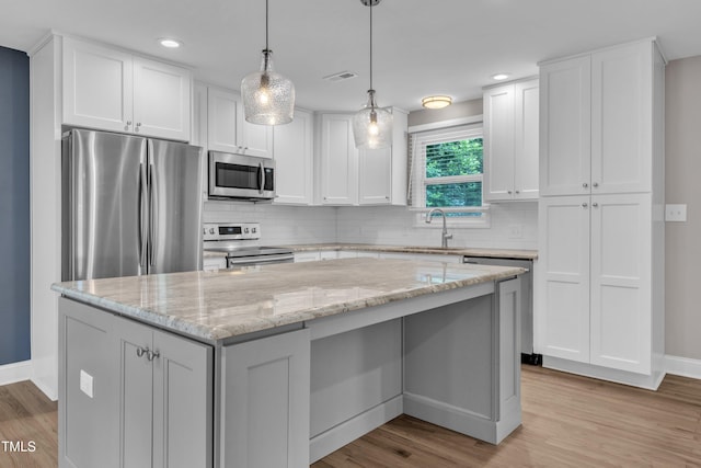 1316 Foxrun Dr, Raleigh, NC 27610 - kitchen featuring stainless steel appliances, white cabinets, backsplash, light wood-style flooring, and recessed lighting