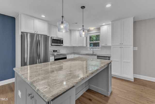 1316 Foxrun Dr, Raleigh, NC 27610 - kitchen featuring appliances with stainless steel finishes, tasteful backsplash, light stone counters, light wood-style flooring, and recessed lighting