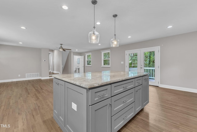 1316 Foxrun Dr, Raleigh, NC 27610 - kitchen with gray cabinets, light wood-style floors, french doors, recessed lighting, and a center island