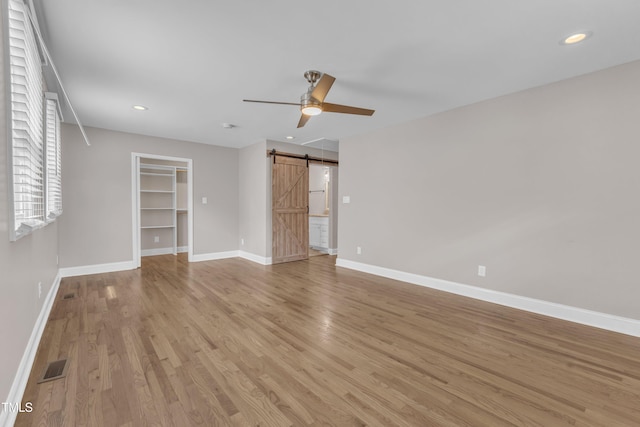1316 Foxrun Dr, Raleigh, NC 27610 - empty room with ceiling fan, a barn door, light wood finished floors, and recessed lighting