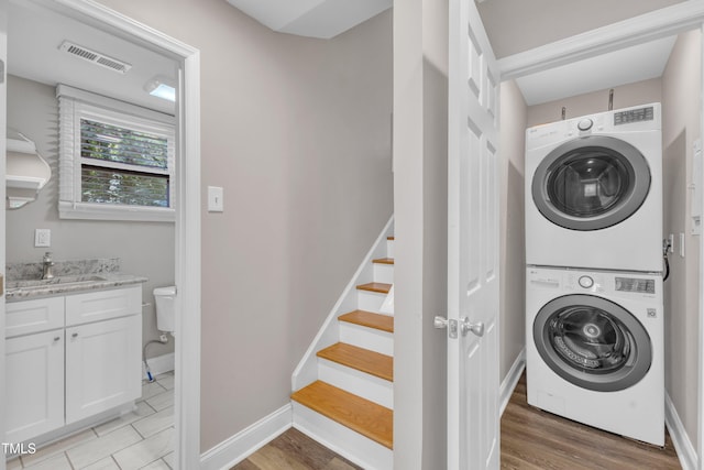 1316 Foxrun Dr, Raleigh, NC 27610 - washroom with estacked washer and dryer and light wood-style floors