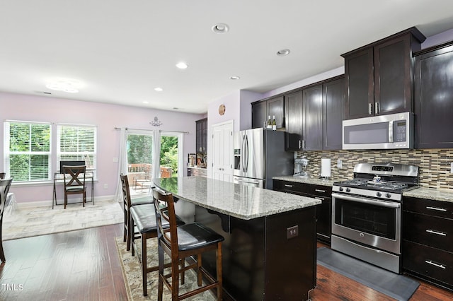 651 Berry Chase Way, Cary, NC 27519 - kitchen with stainless steel appliances, dark wood-style floors, a center island, light stone countertops, and tasteful backsplash