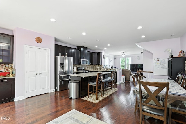 651 Berry Chase Way, Cary, NC 27519 - kitchen featuring appliances with stainless steel finishes, a breakfast bar, a ceiling fan, tasteful backsplash, and recessed lighting