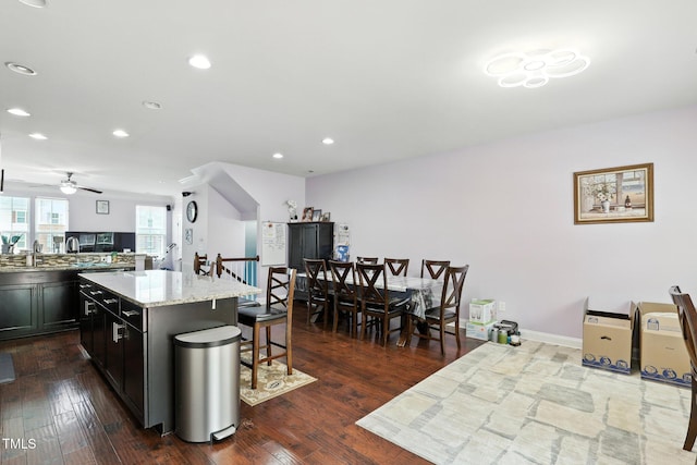 651 Berry Chase Way, Cary, NC 27519 - kitchen featuring a breakfast bar, a kitchen island, recessed lighting, a ceiling fan, and light stone countertops
