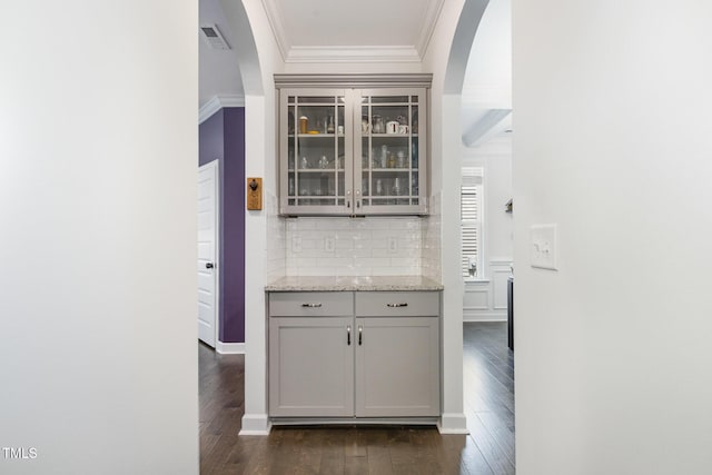 4611 Lazy Hollow Dr, Knightdale, NC 27545 - bar area featuring ornamental molding, arched walkways, dark wood finished floors, and tasteful backsplash