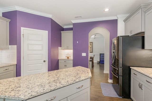 4611 Lazy Hollow Dr, Knightdale, NC 27545 - kitchen featuring freestanding refrigerator, arched walkways, dark wood-type flooring, ornamental molding, and backsplash
