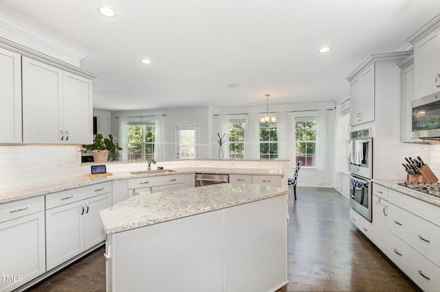 4611 Lazy Hollow Dr, Knightdale, NC 27545 - kitchen with a peninsula, appliances with stainless steel finishes, recessed lighting, backsplash, and light stone countertops