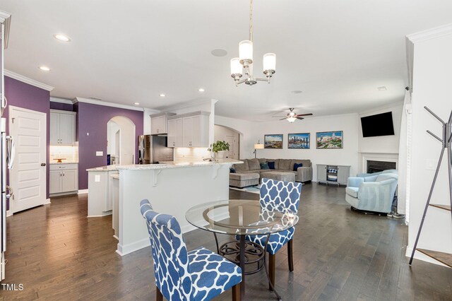 4611 Lazy Hollow Dr, Knightdale, NC 27545 - dining space with arched walkways, a ceiling fan, a chandelier, dark wood-type flooring, and recessed lighting
