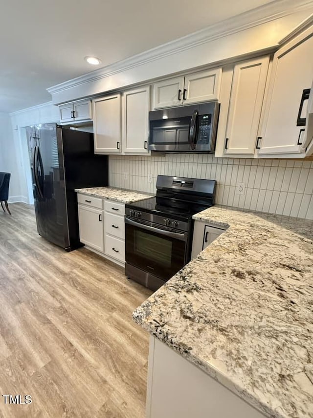 41 Lakewood Dr, Roxboro, NC 27573 - kitchen with appliances with stainless steel finishes, ornamental molding, light stone counters, light wood-style flooring, and decorative backsplash